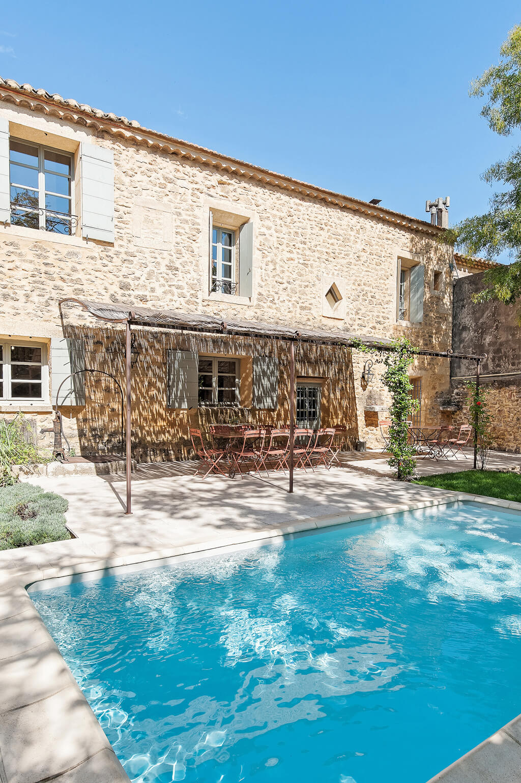 Provence farmhouse pool and outdoor dining in a charming setting.