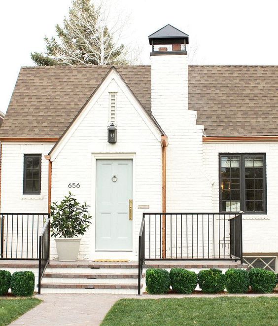 Smukt hvidt Tudor hus udvendigt i Denver af Studio McGee med mursten malet Benjamin Moore China White og hoveddør Greyhound. #whitebrick #studiomcgee #bricktudor #houseexterior #benjaminmoorechinawhite #benjaminmooregreyhound #paintcolors