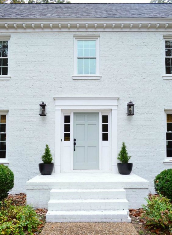 Hvidt murstenshus udvendigt med pastelfarvet hoveddør - Young House Love. #whitebrick #houseexterior #paintedbrick #sherwinwilliamsmodernewhite #benjaminmooretranquility