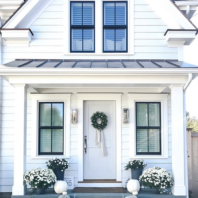 This lovely country farmhouse design features black trim - Design Sixty Five. Charming inspiration if you love white painted house exteriors! #whitehouses #housedesign #exteriors #designinspiration