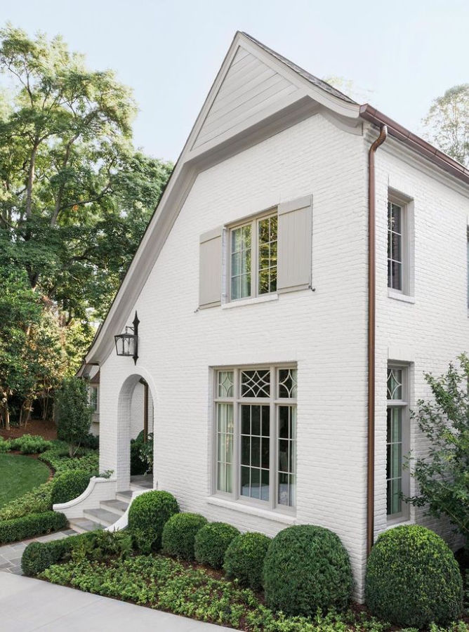 White brick home with arched entrance and light gray trim and shutters - Ladisic Fine Homes & Sherry Hart.. #balboamist #intellectualgray #houseexterior #paintcolors