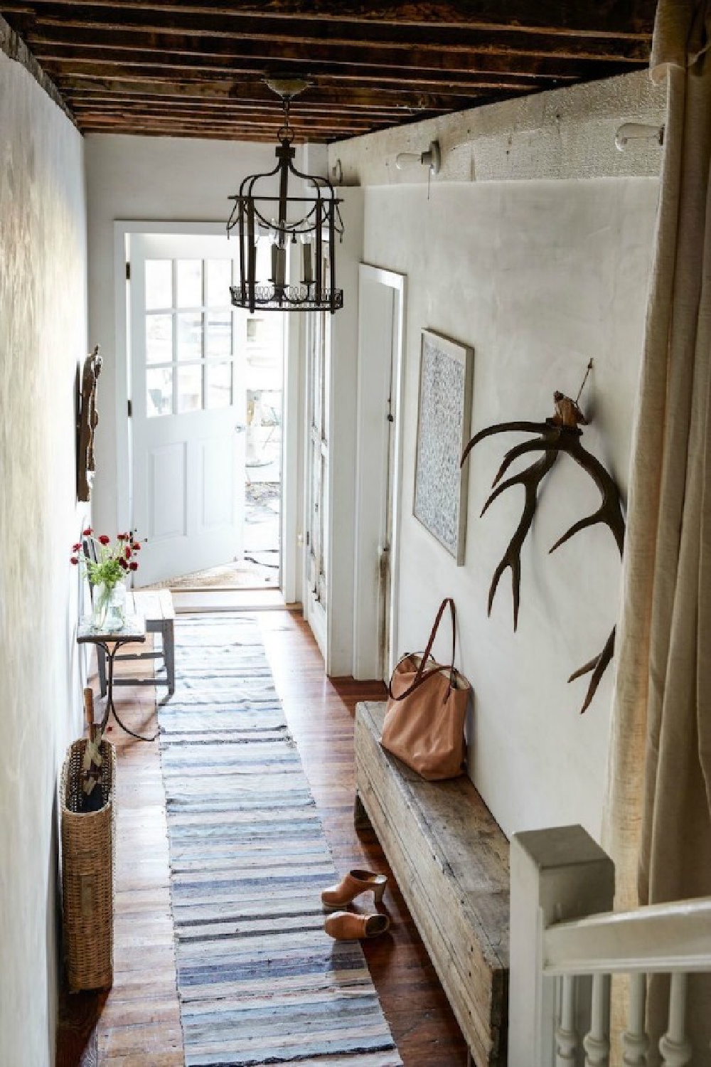 Gorgeous European farmhouse style in a New York apartment entry with rustic finishes and antiques by Jocelyn Sinnauer.