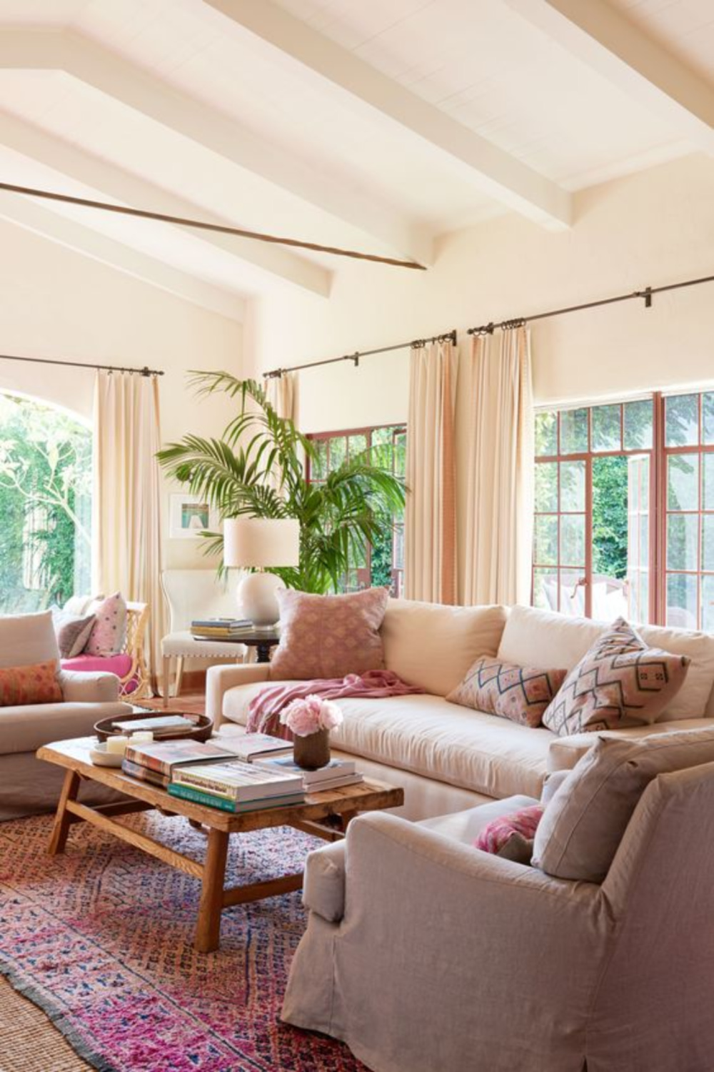 Reese Witherspoon's House in "Home Again" Movie. A pretty living room with California happy chic, linen furniture, and pops of pink. It's actually the living room in the Spanish hacienda of Reese Witherspoon's House in HOME AGAIN. #livingroom #california #reesewitherspoon #homeagain