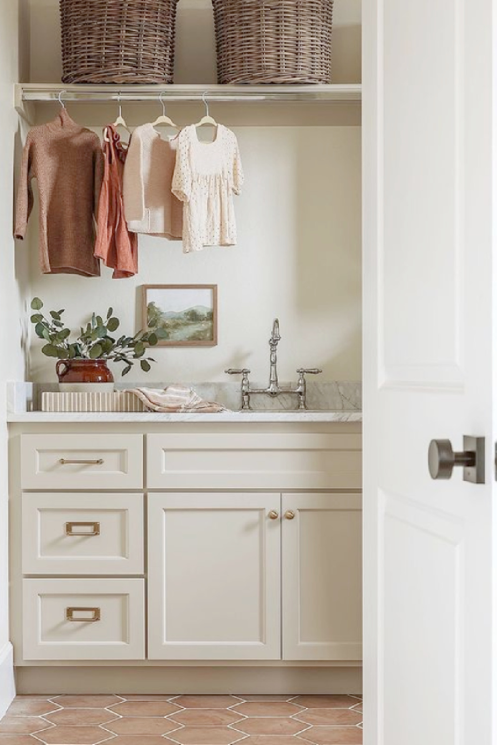 Sophisticated laundry room with putty cabinets, terracotta hex tile, and bridge faucet - Kelsey Leigh Design Co. #laundryrooms #interiordesign