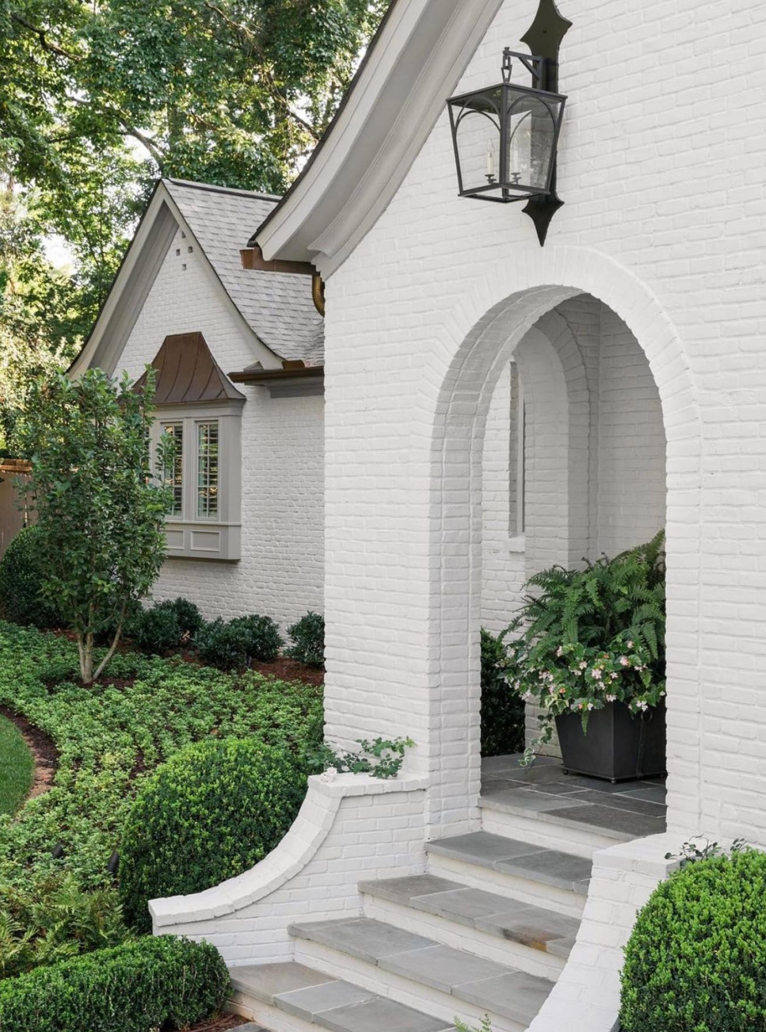Balboa Mist (Benjamin Moore) on brick exterior of a lovely home with arches (Ladisic Fine Homes) - Sherry Hart. #balboamist #benjaminmoorebalboamist #paintcolors #housecolors