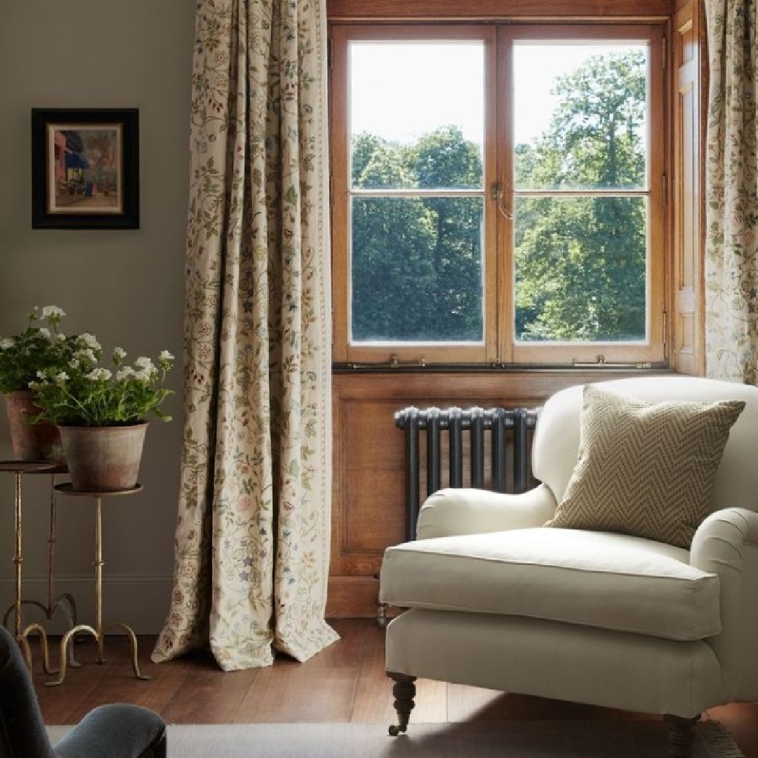 English country interior with comfortable arm chair at window at Heckfield Place.