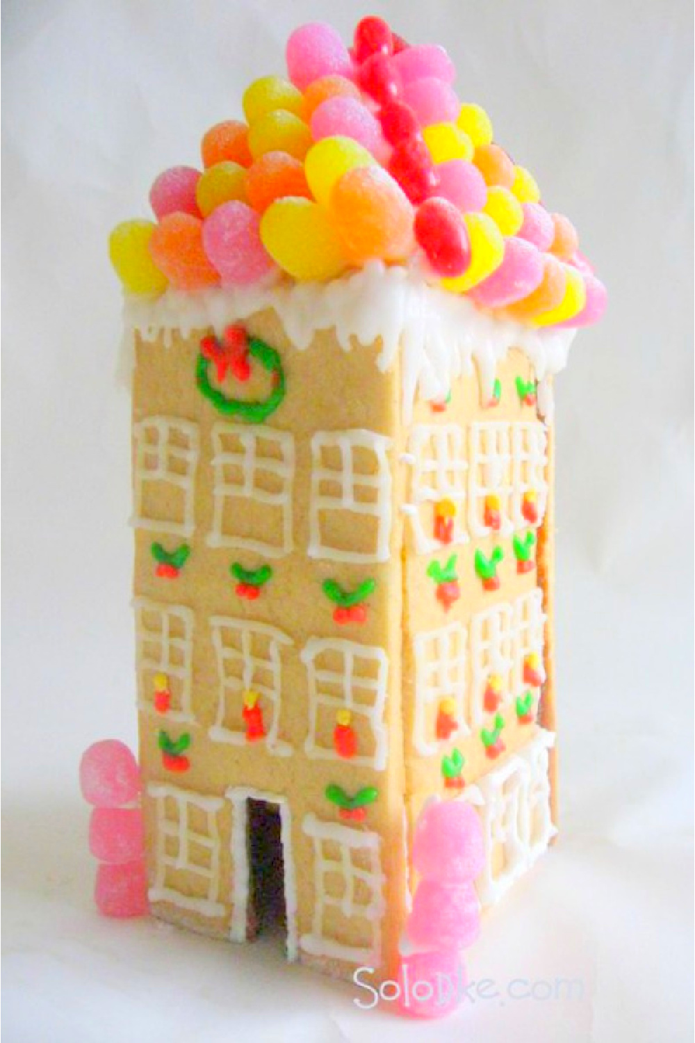 Magnificent sugar cookie townhouse with fanciful gumdrop decorated roof! Solodke. #gingerbreadhouse #candyhouse #gumdrops #holidaydiy