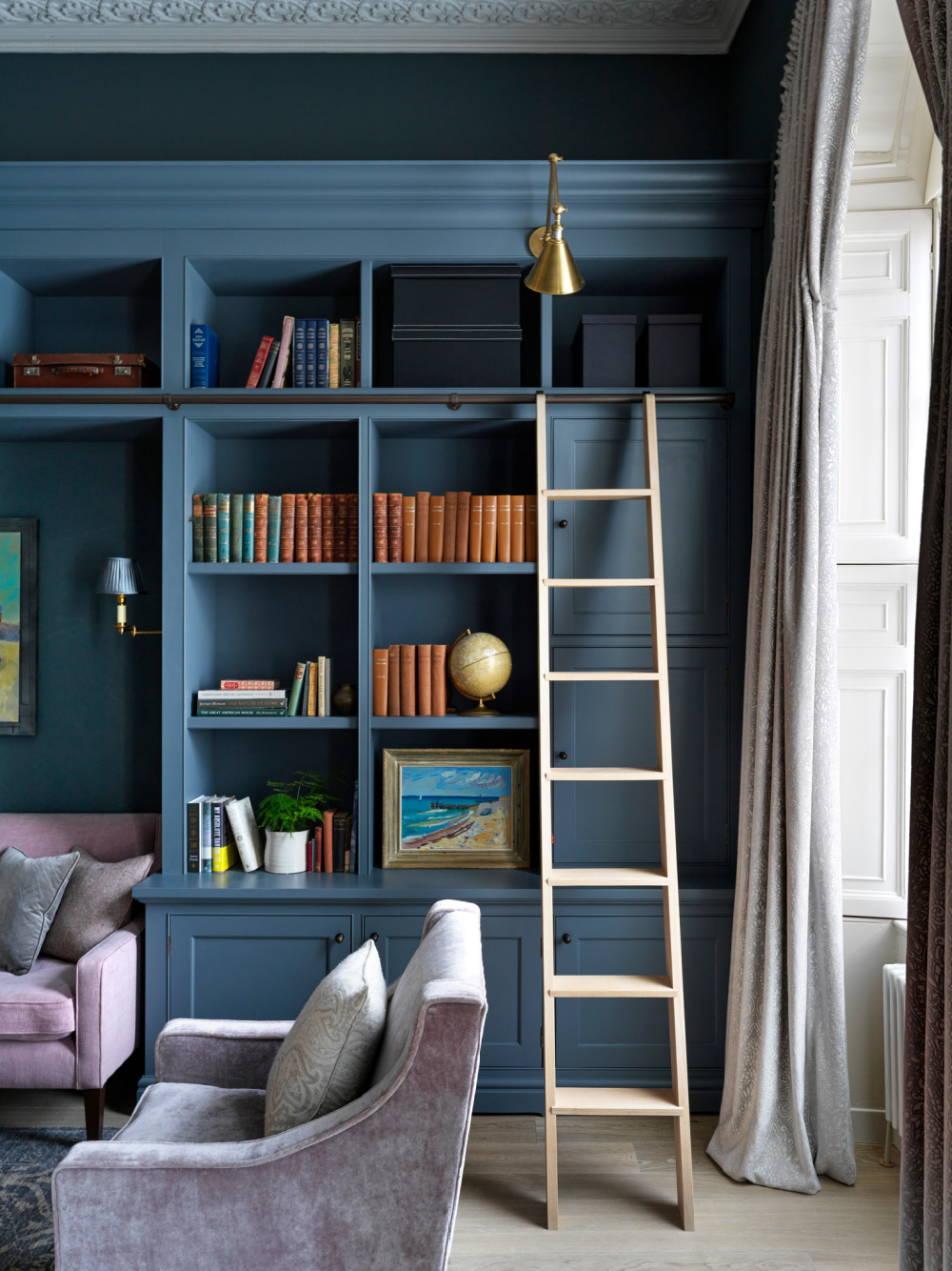 English Country blue painted library built-in shelves and ladder - with design by Sims Hilditch in THE EVOLUTION OF HOME (Rizzoli, 2022).