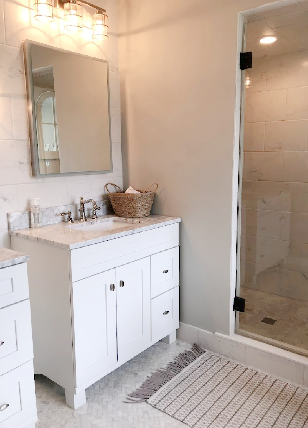 White Shaker style bath vanity with Edwardian style polished nickel faucet and modern mirrored medicine cabinet in our modern French renovated bath - Hello Lovely Studio.