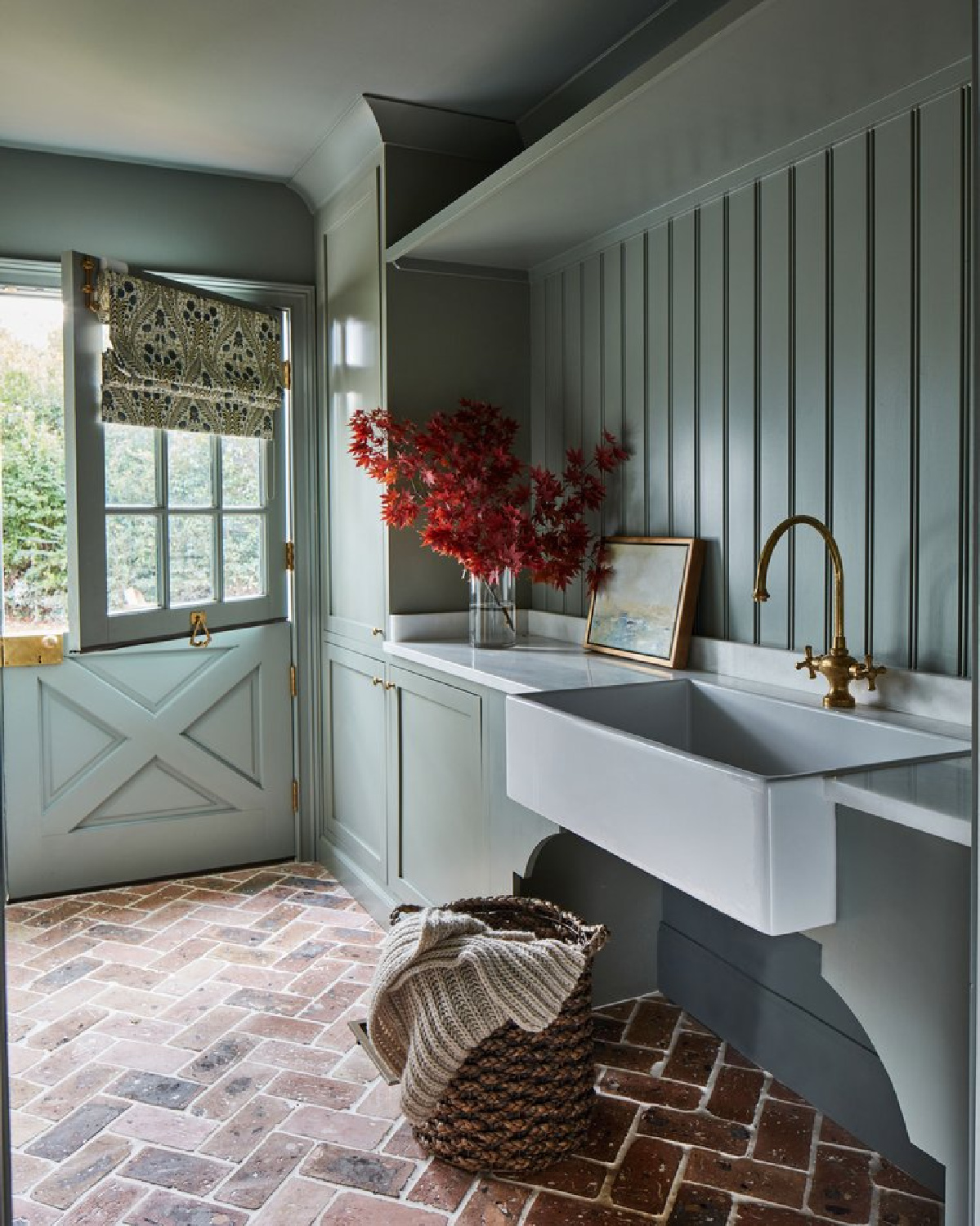 English country style green mud room with Dutch door, boarded walls, farm sink and herringbone brick floor. @riverbrook_