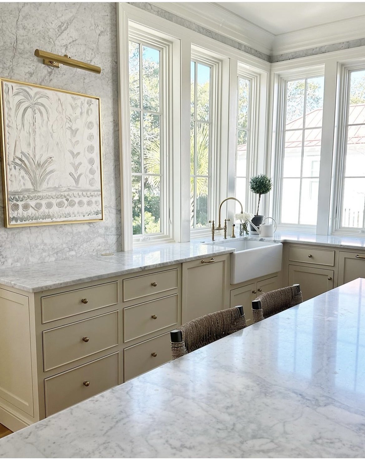 Betsey Mosby Interiors designed bespoke kitchen with farm sink, white marble, and warm beige cabinetry. #timelesskitchens #bespokekitchendesign