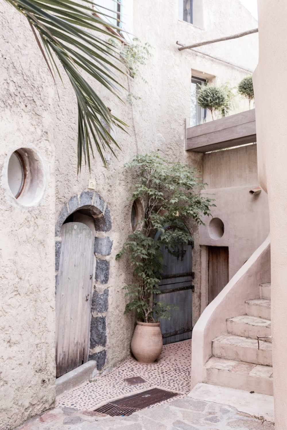 Rustic Old World pale stone buildings in Provence and arched door - The Flying Dutchwoman. 