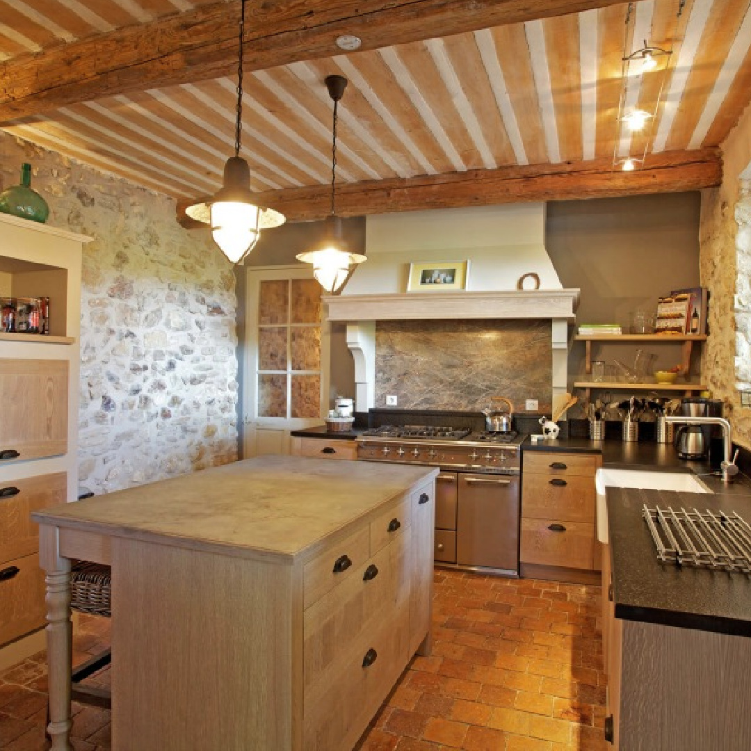 French farmhouse kitchen in Provence with rustic wood beams, warm stone walls, and modern appliances - Bonnieux Villa (Your Haven in Paris.)