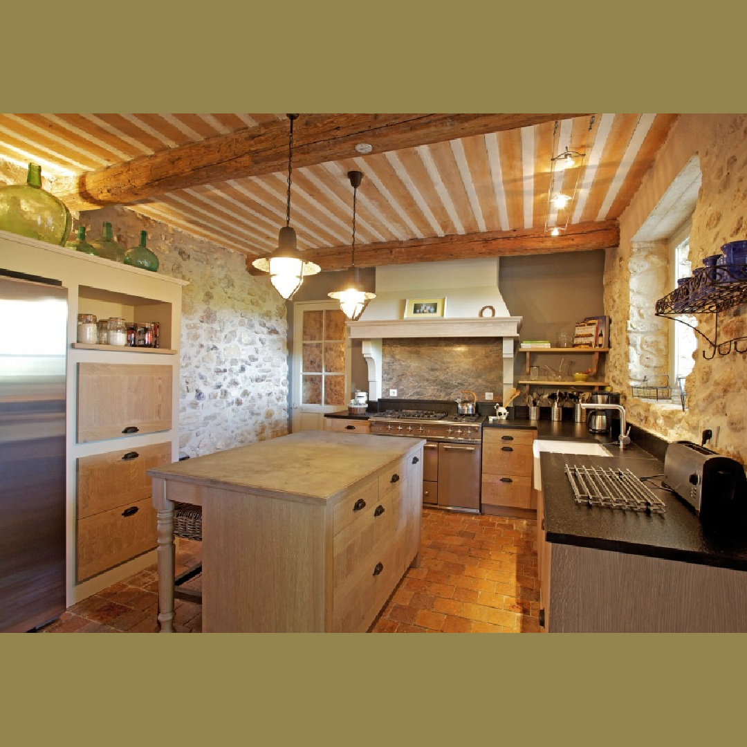 French farmhouse kitchen in Provence with rustic wood beams, warm stone walls, and modern appliances - Bonnieux Villa (Your Haven in Paris.)