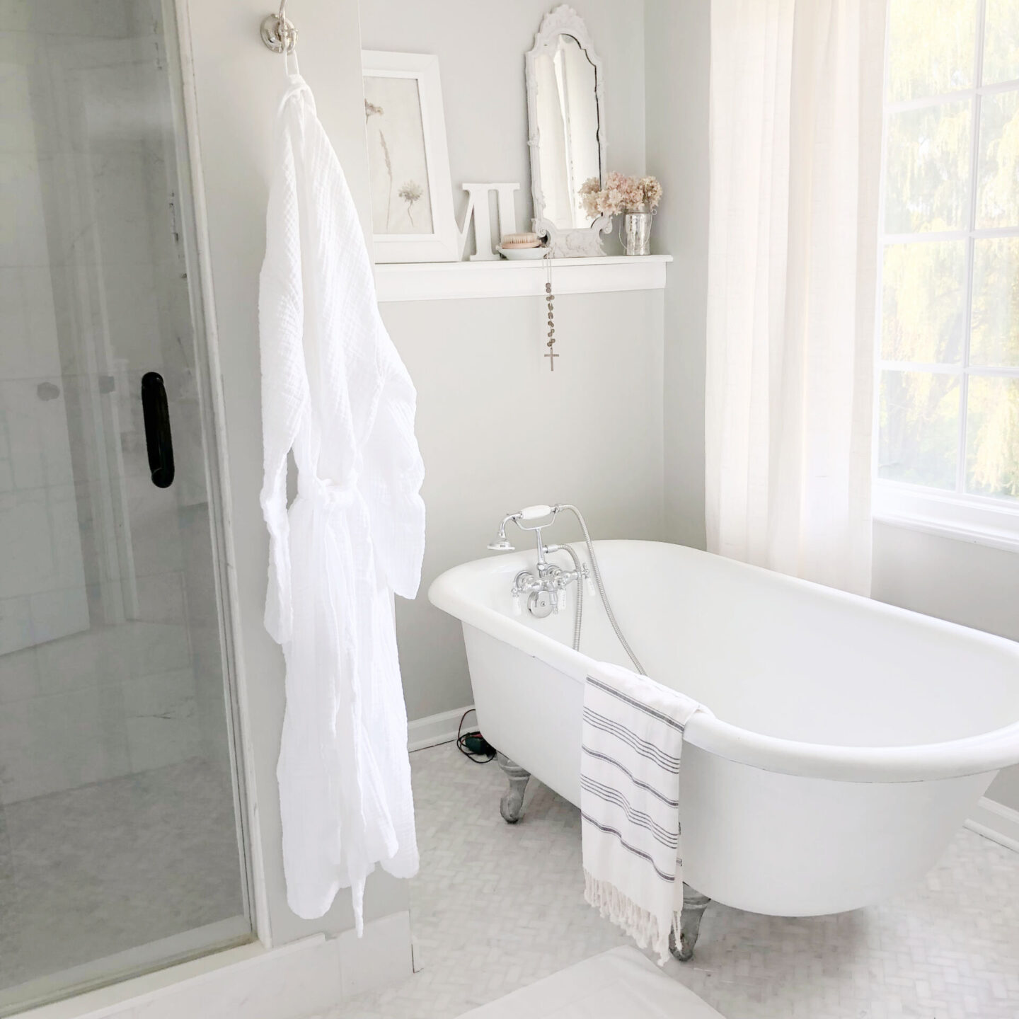 Hello Lovely's serene modern French bathrom with clawfoot tub, white muslin robe (Loom.ist from AWAREHOUSESHOP), and SW Repose Gray walls. #serenedecor #sherwinwilliamsreposegray