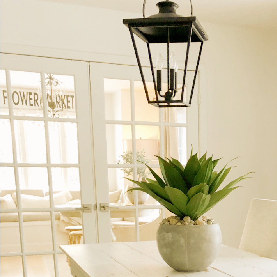 Belgian style minimal modern rustic dining room with agave succulent in pot on white farm table - Hello Lovely Studio.