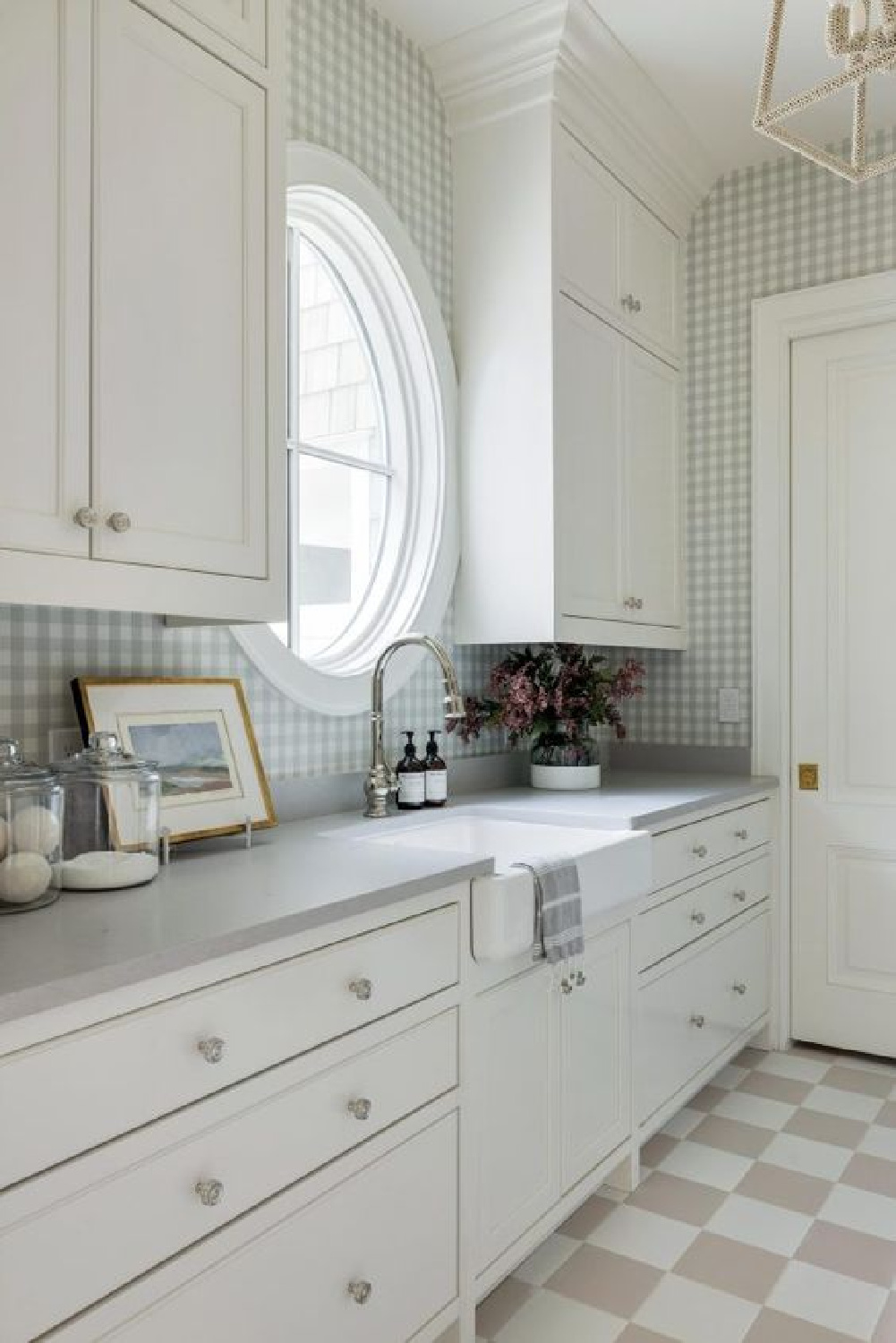 Checkered floor tile, white cabinets, and an oval window in a lovely laundry room by Bria Hammel Interiors. #cuterooms #checkeredfloor #dreamhousedecor