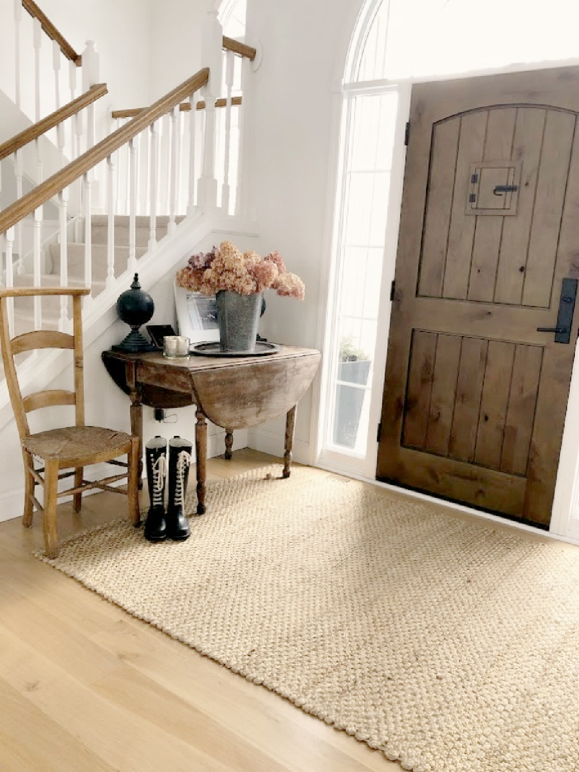 Rustic European country entry with knotty alder front door and neutrals - Hello Lovely Studio. #modernfrench #frenchfarmhouse