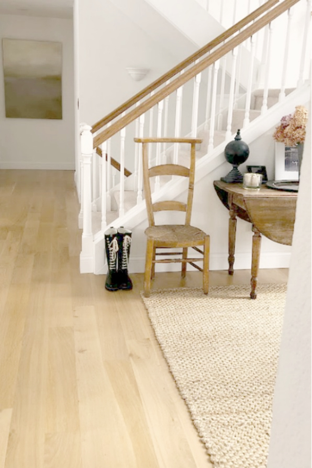 White oak hardwood flooring and antique French prayer chair in Hello Lovely's modern rustic European country entry.