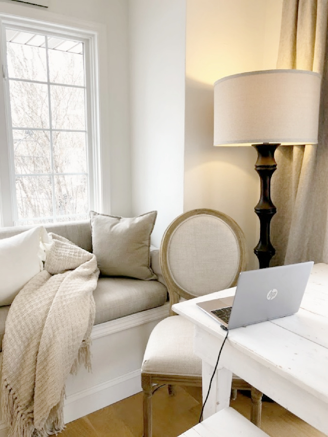 Window seat and neutral accents in Hello Lovely's modern European country serene kitchen painted BM White OC-151.