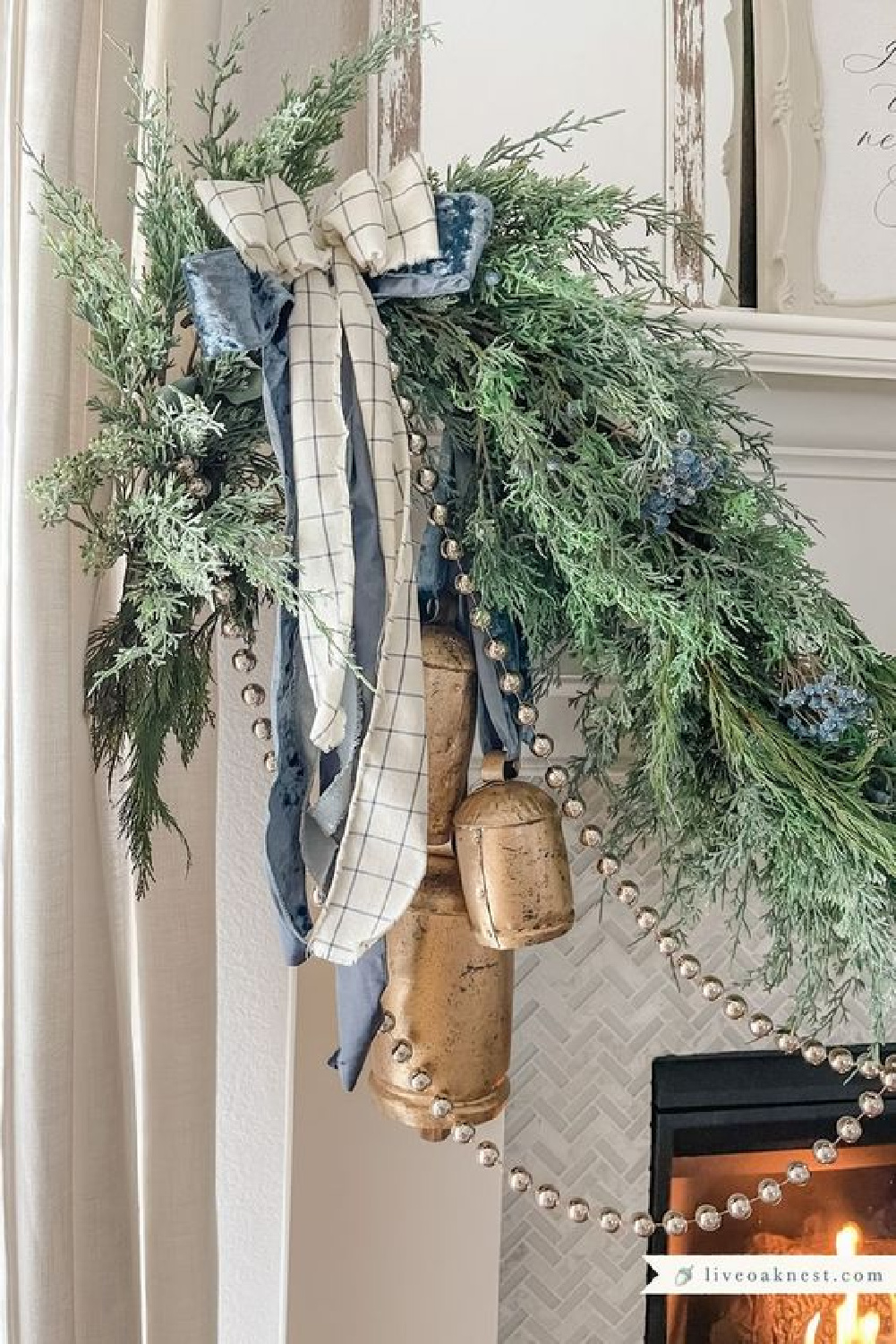 Holiday decorated fireplace garland swag with evergreens, rustic ribbon and bells - Live Oak Nest.