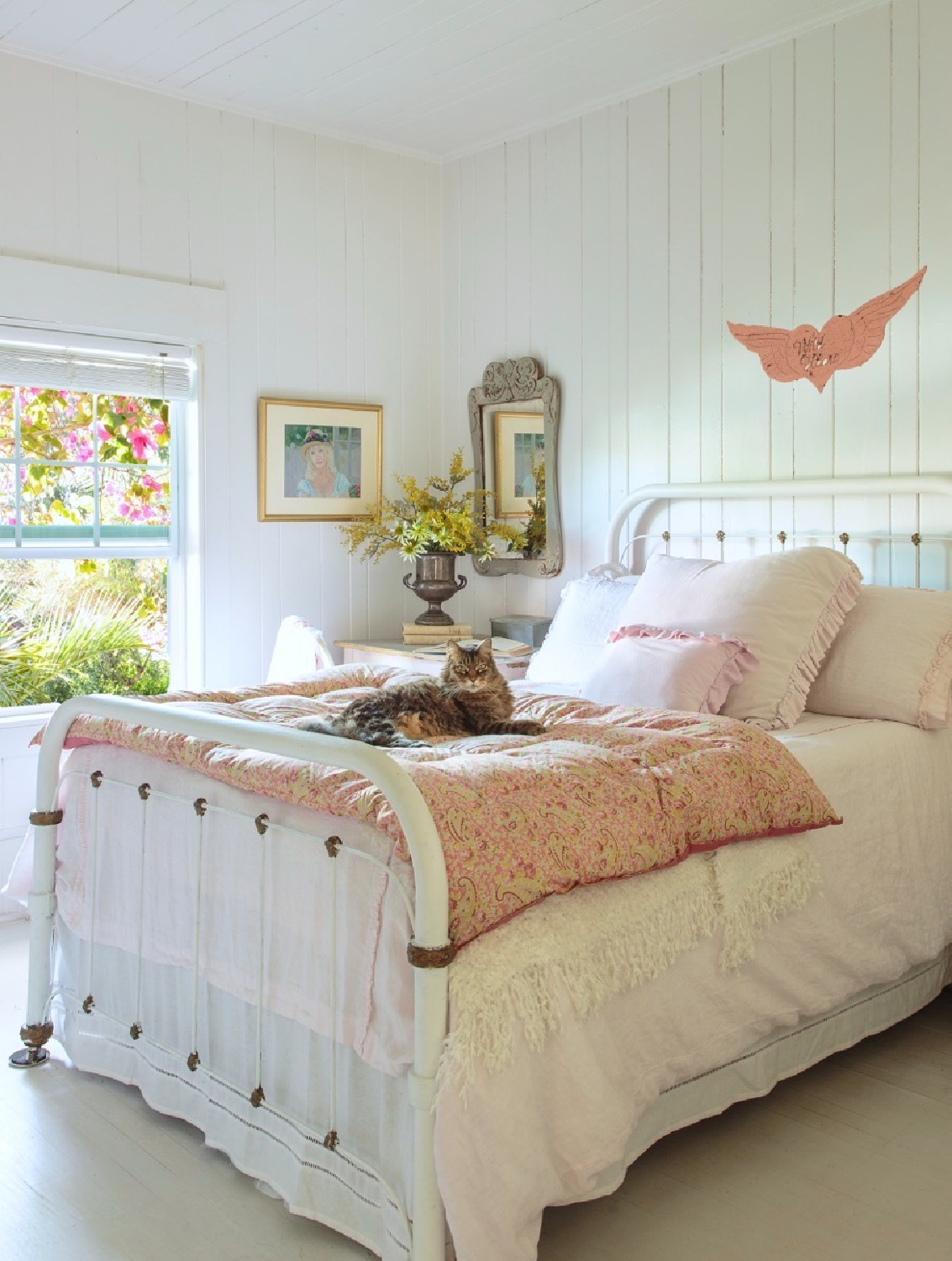 Serene white cottage bedroom with cat in Fifi O'Neill's romantic Florida cottage with white shiplap. #coastalcottage #cottagebedroom #romanticdecor