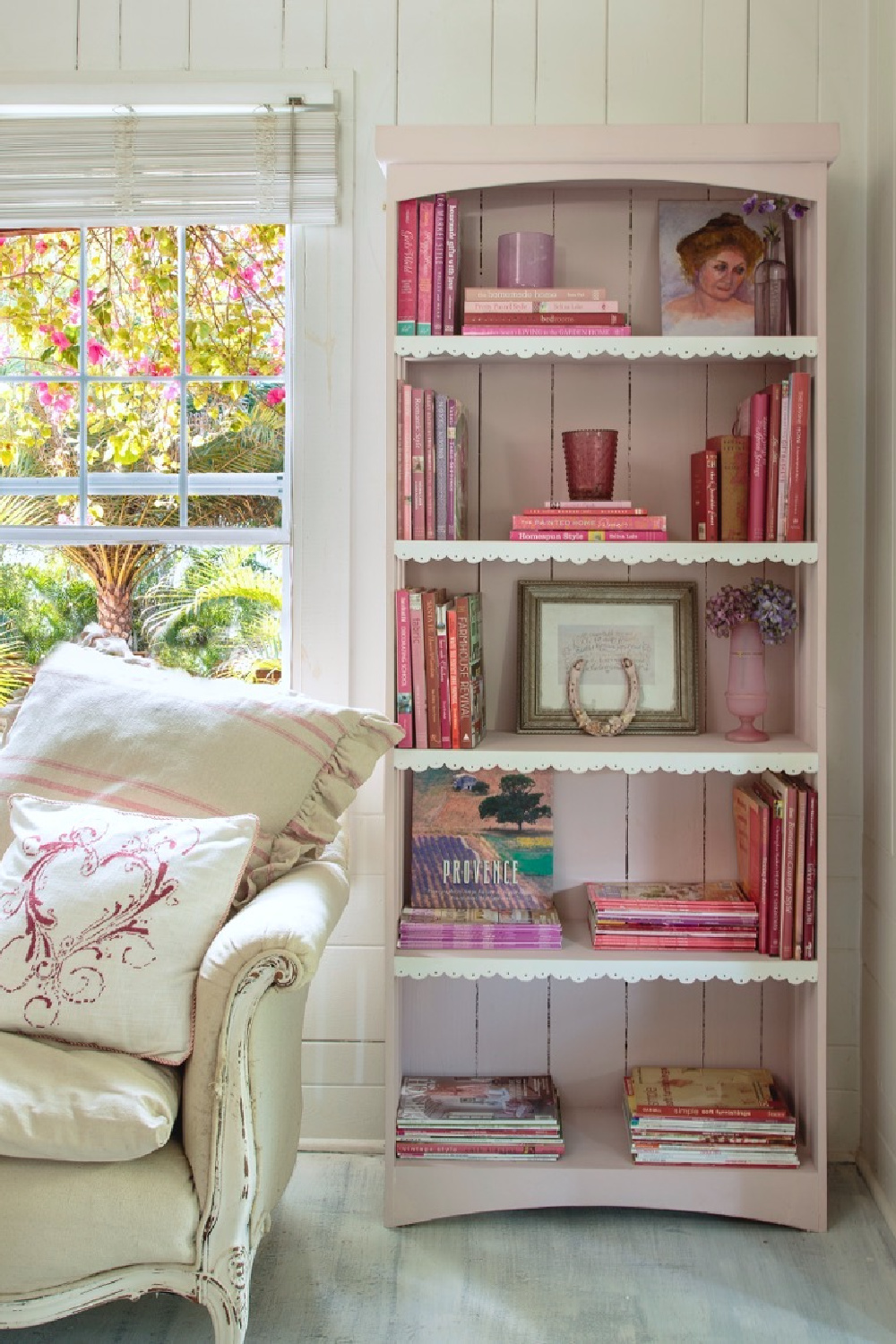 Rosy pink (Antoinette by Annie Sloan) bookshelf interior in Fifi O'Neill's cozy Florida cottage with rustic romantic decor. #coastalcottage #countrycottage #romanticdecor