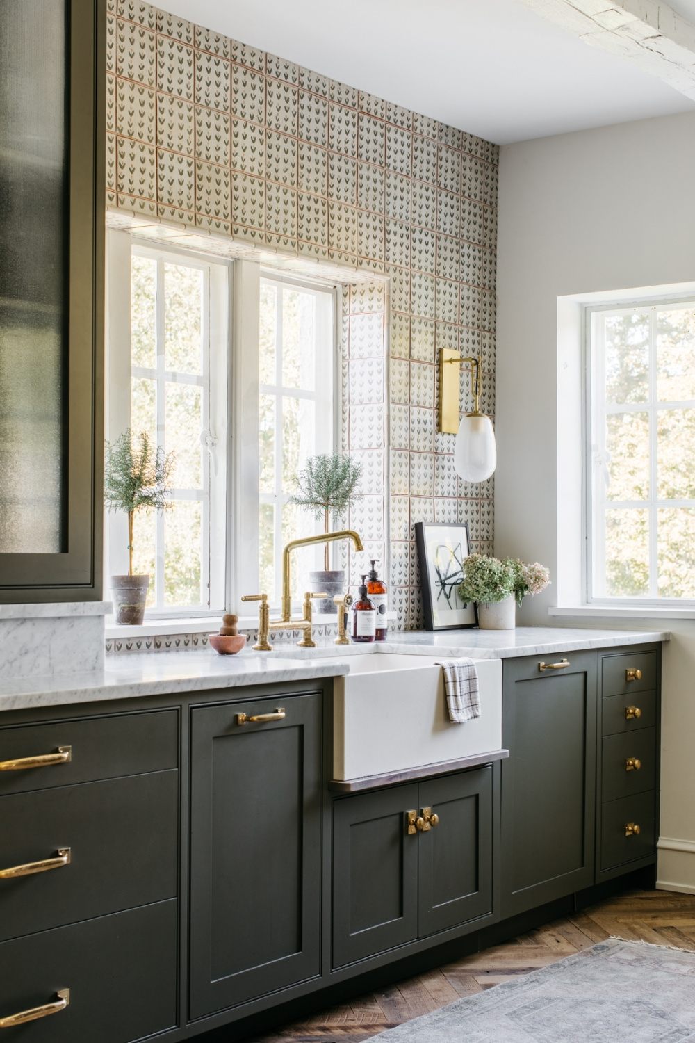 Kate Marker designed kitchen with deep green painted cabinets, farm sink, and patterned backsplash to ceiling. #benjaminmooredarkolive