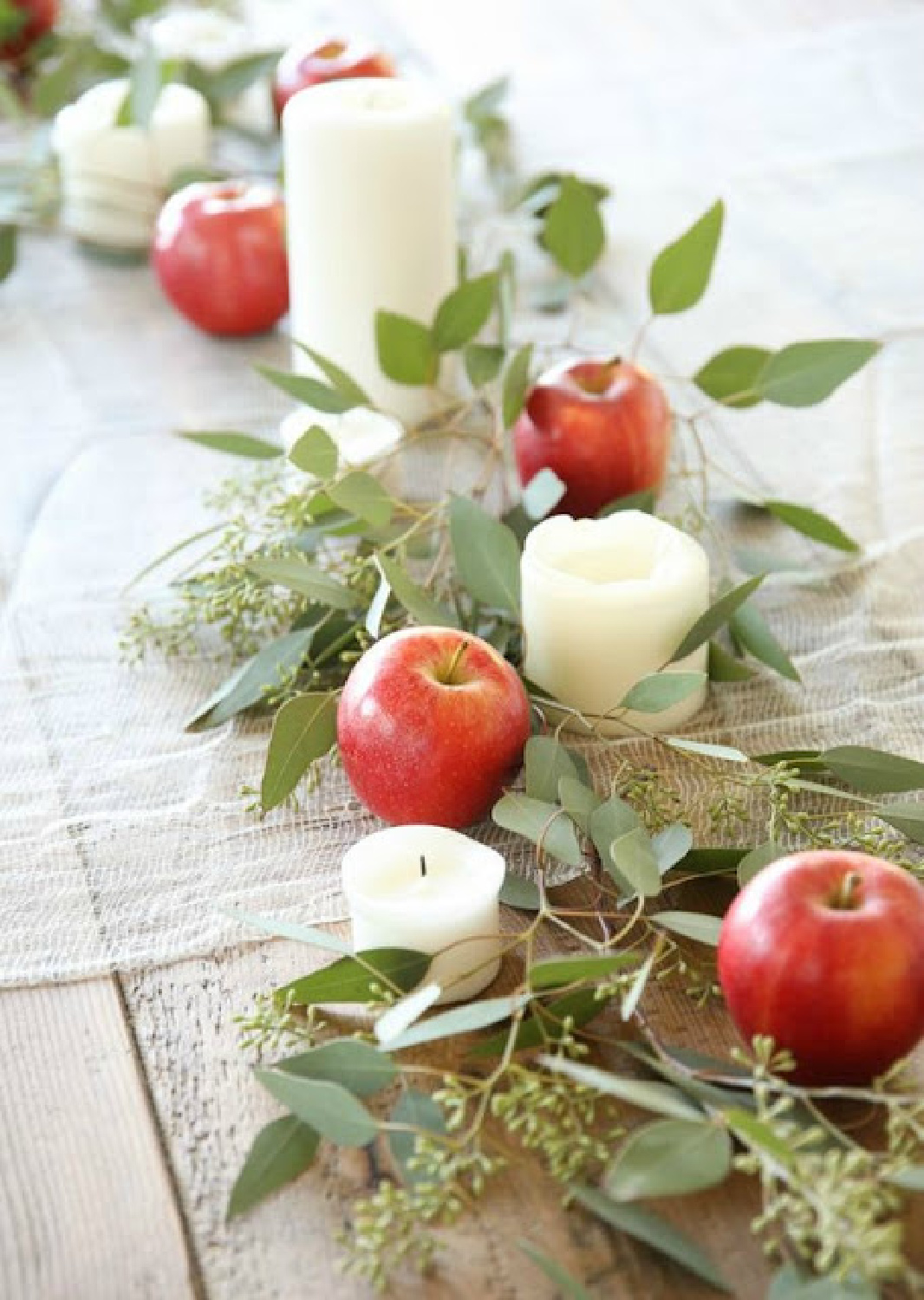 Simple fall tablescape floral idea with greenery, apples, and candles - Rosemary-Thyme. #falltabledecor #falltablescapeideas