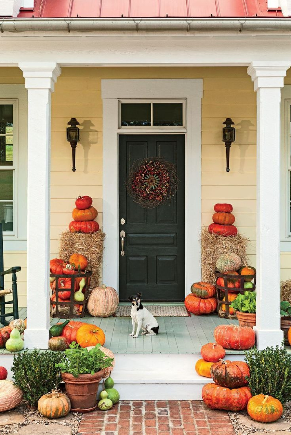 Beautiful fall decor on a front porch with rustic hay bales, pumpkins, and autumn charm - Southern Living. #fallporchdecor