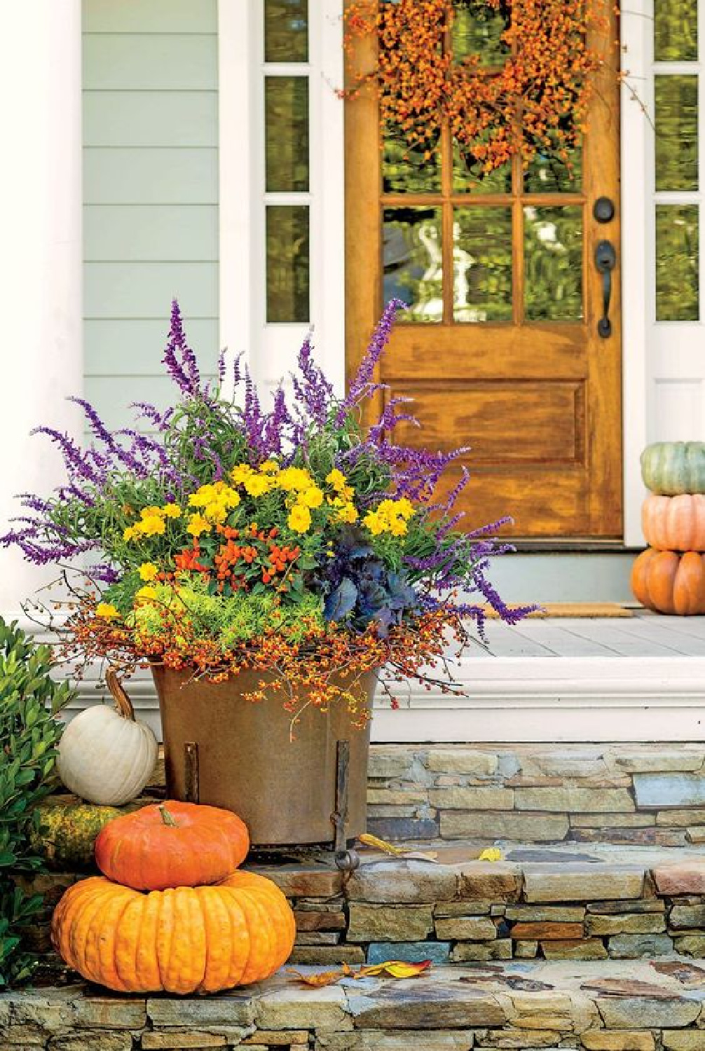 Fall front porch colorful decor including planter, dog, and pumpkins - Southern Living. #autumndecor #fallporchdecor