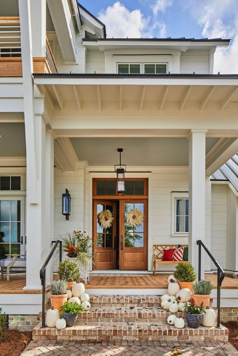 Fall decor on a front porch with dog, pumpkins, and planters - Southern Living. #autumndecor #fallcurbappeal #fallporchdecor