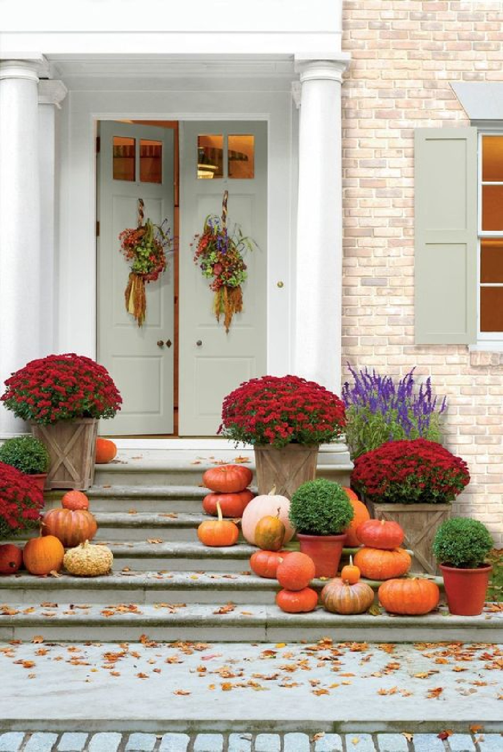 Beautiful FALL front porch with pumpkins and mums on steps - Southern Living. #fallporch #falldecorating #fallpumpkins